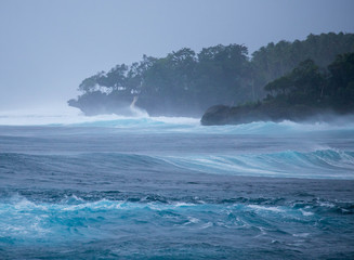 Powerful ocean swells and wind whipped spray along tropical coast