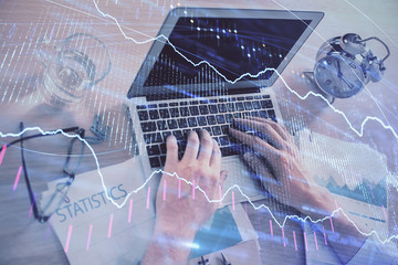 Multi exposure of forex graph with man working on computer on background. Concept of market...
