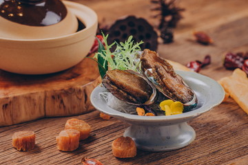 Three abalone, cooked in stock, garnished with vanilla.