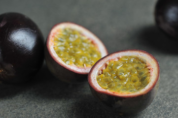 Passion fruit is the fruit of a tropical vine. Two halves of passion fruit and whole fruits....