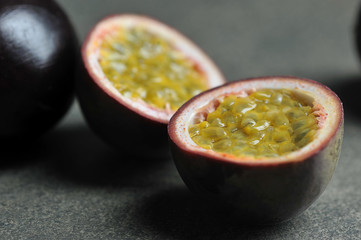 Passion fruit is the fruit of a tropical vine. Two halves of passion fruit and whole fruits....