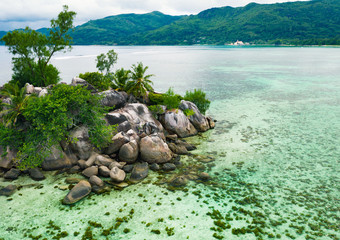 Tropical beach with rocks and trees on Seychelles island.