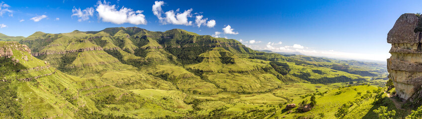 Panorama over soft green mountains, on a sunny day, on the right hand is a rock formation called Sphinx, Drakensberg, Giants Castle Game Reserve, South Africa