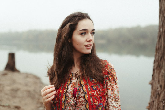 Portrait of a young hippie girl by the lake natural beauty long brown hair