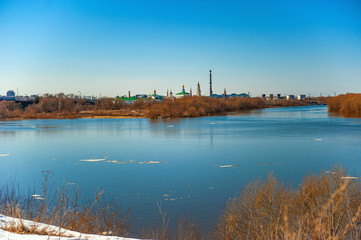 Spring natural landscape of spring flood. Ice floes float on the river in the ice drift. Sunny day with blue clear sky