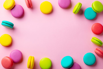 Macaroons dessert on pink pastel background. Copy space. Top view.