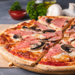 Closeup photo of delicious  pizza with mushrooms and ham.