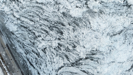 Aerial view of a frozen river. Fancy ice texture, cold chained water. Shards of ice stick out with sharp edges.