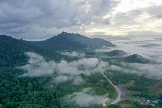 Aerial view misty and foggy morning at the Imbak Village in Tongod, Sabah, Malaysia, Borneo. Certain part with rainforest jungle and palm oil plantation.