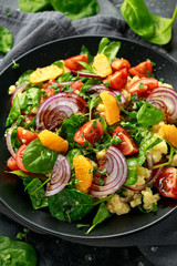 Vegetable Millet salad with red onion, cherry tomatoes, spinach, tangerine and clementine dressing. healthy food
