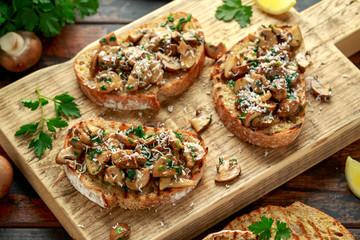 Grilled mushroom toast with parsley, lemon and parmesan cheese on wooden board. healthy vegan food
