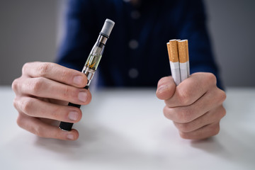 Man Holding Vape And Tobacco Cigarettes