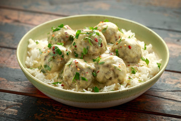 Hot Swedish meatballs with white rice on wooden table