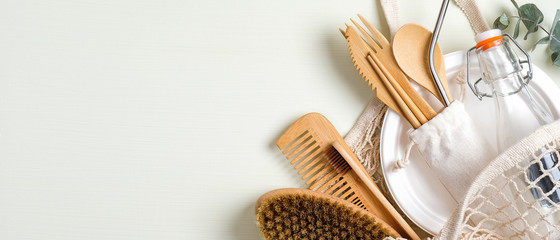Set of eco friendly bamboo cutlery, mesh shopping bag, massage brush, glass bottle, bamboo toothbrush, wooden hair comb. Zero waste concept. Sustainable lifestyle. Eco store banner mockup