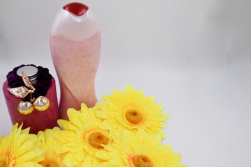 Bath accessories are placed on a white background - shower gel, mousse, elastic for hair, jewelry.