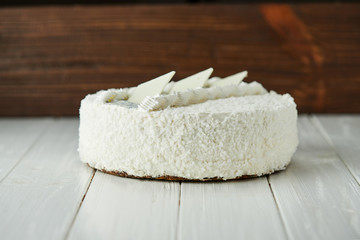 Birthday cake with white chocolate, butter cream and poppy seed biscuit on wooden background