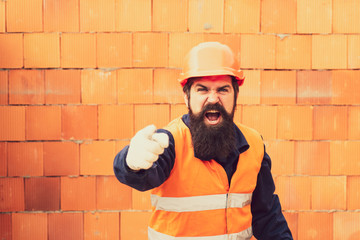 Labor Day. Builder screams and shows finger forward. Bearded man worker.