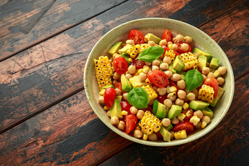 Avocado chickpea salad with grilled sweet corn, tomato and basil. Healthy vegan food