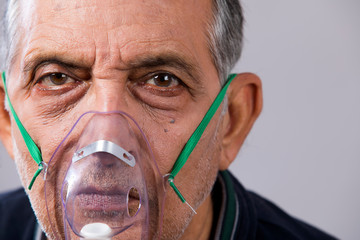 Portrait of a senior man wearing an oxygen mask.  (Health and Fitness) 