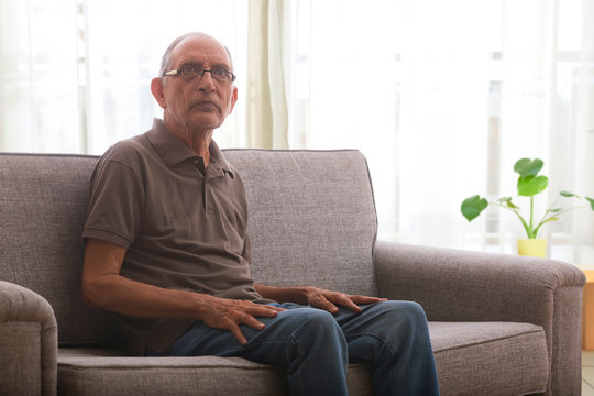 Portraits Of A Senior Man Sitting On Couch At Home. 