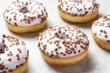 Close up on tasty donuts with sugar icing and chocolate chips. Sweet pastry.