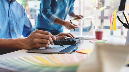 Professional Creative architect graphic desiner occupation choosing the Color pantone palette samples for project on office desktop computer