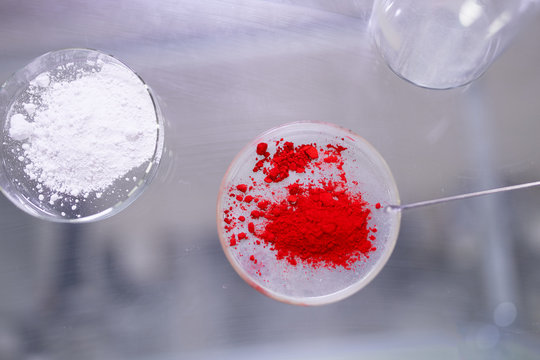 Two cups of petri dishes with red and white powder in laboratory