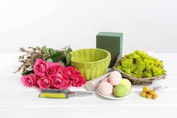 Woman shows how to make Easter table decoration with roses, moss and catkins