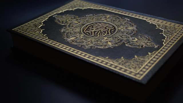 light on Quran Islam holy book of Muslims, the Quran, is placed on table , Holy Quran with arabic calligraphy meaning of Al Quran, islamic background 
