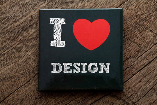 I Love Design written on black note with wood background