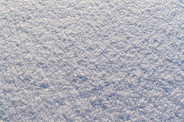 Fresh snow as a winter background. Snowy surface backlit.