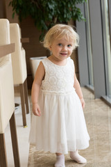 little girl in white dress indoors at home
