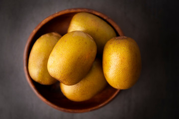 Golden kiwis in the wooden bowl