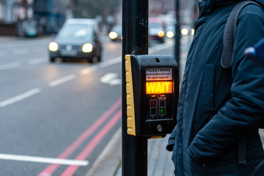 Crosswalk button for pedestrian with light warning on a defocused background , London, UK