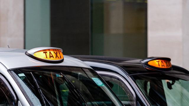A british london black taxi cab sign with defocused  background