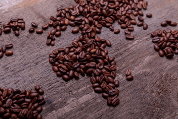 Dramatic photo of world map made of arabic roasted coffee beans on old vintage wooden table.