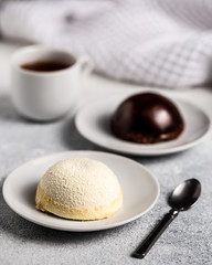 Two cheesecakes with caramel and chocolate on light grey background