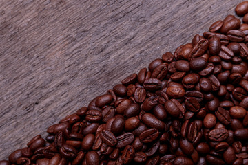 Coffee beans on old vintage wooden background with copyspace for text. Coffee background or texture concept.