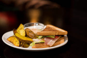 sandwich with beckon and fried potatoes
