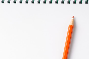 open notebook with red pencil on white table