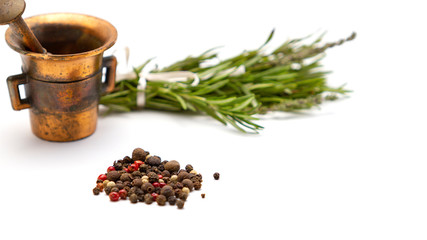 Composition of fragrant herbs-rosemary and thyme, black, pink and white pepper, copper mortar for seasonings, close-up, isolated on a white background. For menus, greetings, labels, and packaging.