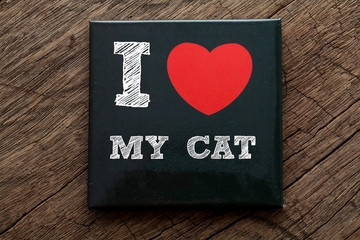 I Love My Cat written on black note with wood background