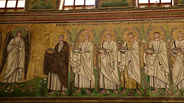 Ravenna, Italy, December 2019. Basilica of Sant'Apollinare Nuovo. Footage with pan movement on the detail of the mosaics along the sides of the main nave. Jesus with angels beside receives the martyrs