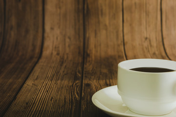 Black coffee in a white mug on a wooden table