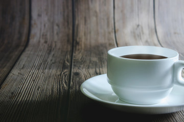 Black coffee in a white mug on a wooden table