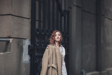 Obraz premium charming woman in a spring coat looks at the camera