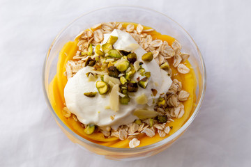 Mango with yogurt, muesli cereals and pistachio