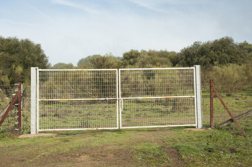 Entrance gates on country farms in Andalusia are very frequent, older or more modern, connecting meadows on sunny or foggy days