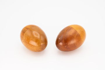 Two wooden egg shaker in front of a white background