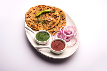 Onion Parotha / Pyaj parantha / kanda paratha served with tomato ketchup and green chutney. selective focus